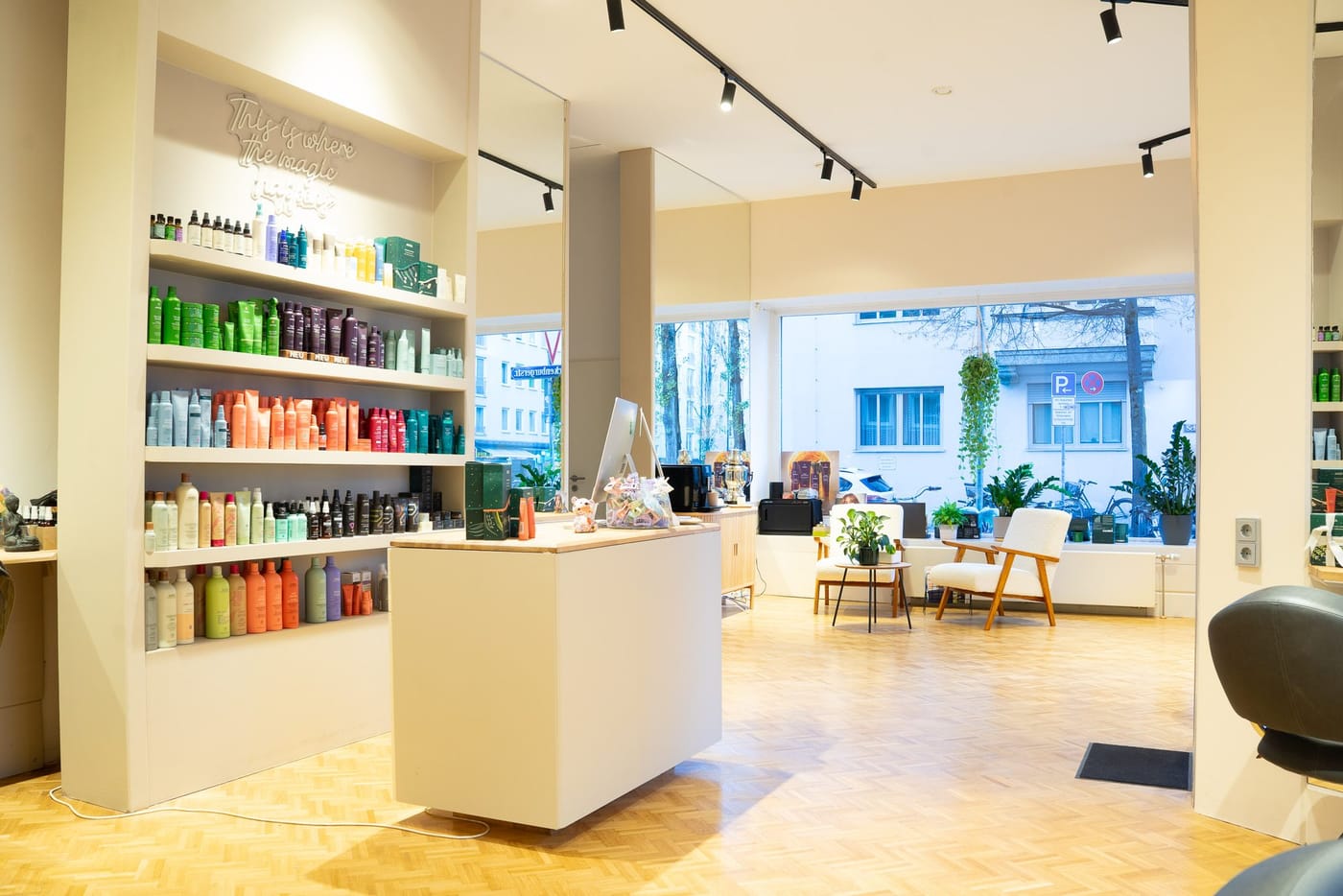 Das Aveda-Regal im Salon mit dem Schriftzug an der Wand